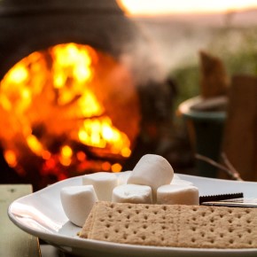 image of graham crackers, marshmallows, and chocolate in front of a fire